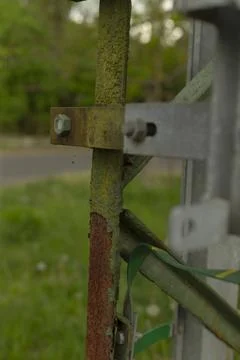 Green strap and cable ties highlight recent fixings on aged post structure Stock-Fotos