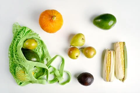 Green string eco shopping bag with vegatables avocado, corn, lemon and pumpkin Stock Photos