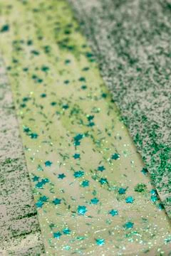 Green striped background with star sequins Stock Photos
