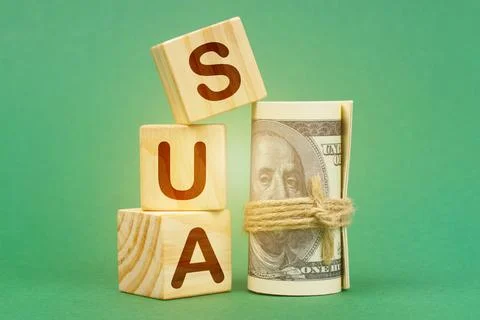 On a green surface, dollars and cubes with the inscription - SUA 스톡 사진