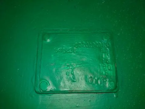 A Green Surface Features a Rectangular Sign With Embossed Text Indicating I.. Stock Photos