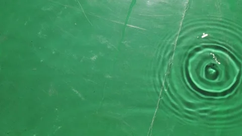 A green surface with a large circular splash of water Stock Footage 274859786