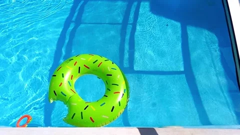 Green swimming ring floating in empty transparent swimming pool. Video stock 282616249