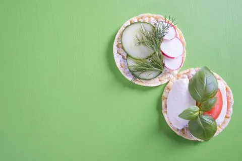 On a green table are corn waffles and on it tomatoes, mozzarella, radish, cuc Stock Photos