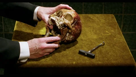 On a green table the dentist uses an old device to remove a tooth from the skull Stock Footage 221844118