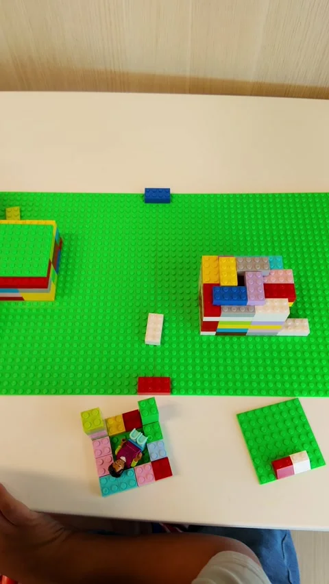 A green table with a green mat and a pile of legos Stock Footage 328775498