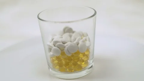 Green Tablets Fall into a Glass Cup to the Tablets and Vitamins. Medicines and P Stock Footage 126225679
