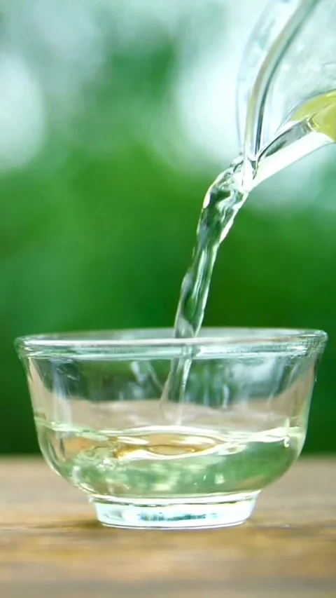 Green tea being poured into a small glass cup Video stock 331932670