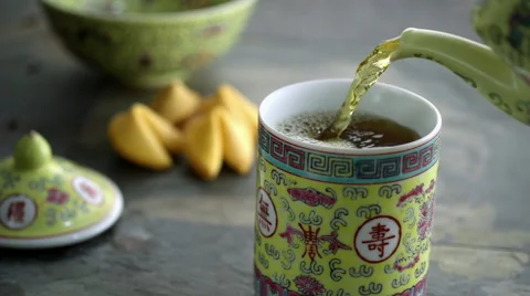 Green tea being poured in yellow cup Stock Footage