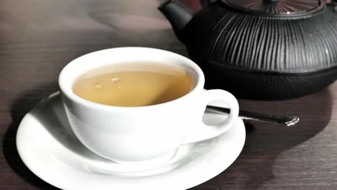 Green tea cup and pot on wooden table Stock Footage 162891036
