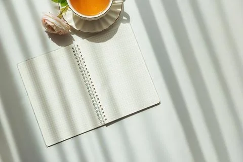 Green Tea Cup with Notebook and Ranunculus Flowers on White Table Stock Photos