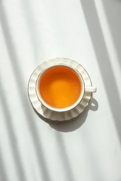 Green Tea Cup on White Table under Sunlight with Shadow Stock-Fotos