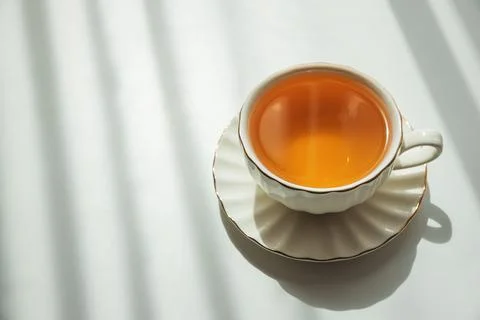 Green Tea Cup on White Table under Sunlight with Shadow Stock-Fotos