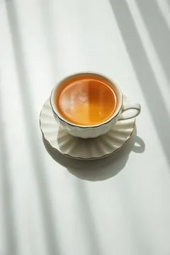 Green Tea Cup on White Table under Sunlight with Shadow Stock Photos