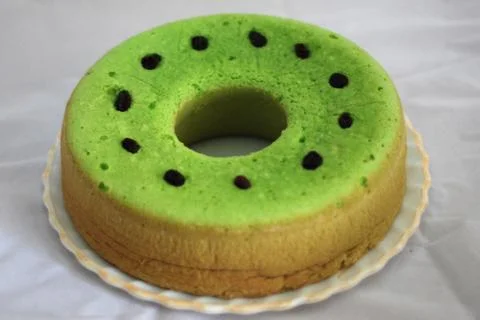 Green tea flavored sponge bread light green with raisin seeds above it Stock Photos