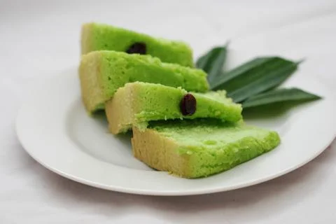 Green tea flavored sponge bread light green with raisin seeds above it Stock Photos