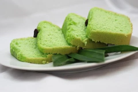 Green tea flavored sponge bread light green with raisin seeds above it Stock Photos