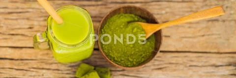Green tea latte with ice in mason jar, matcha powder and candy made of matcha on Stock-Fotos