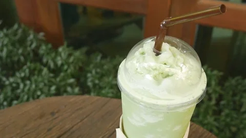 Green tea matcha smoothies in a plastic cup on the table Video stock 78141778