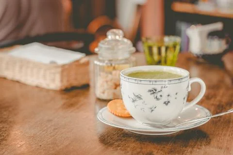 Green tea matcha soy latte in a china cup with brown sugar and a glass of wat Foto stock