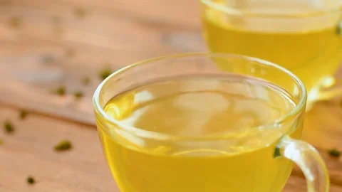 Green tea with mint, rose, goji berries and pineapple in cups Video stock 73601836