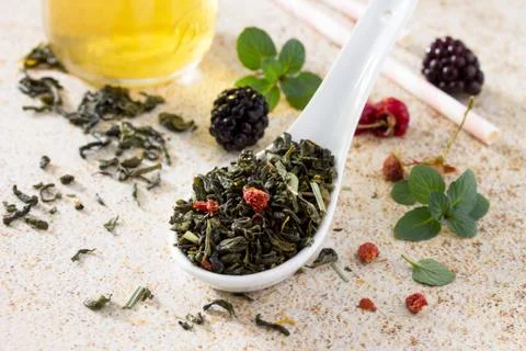 Green tea with raspberry, strawberry and mint on a slate background. Stock Photos