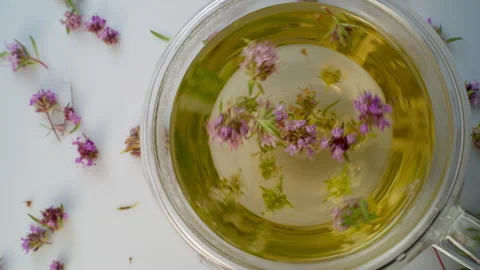 Green tea with thyme flowers in a cup. Stock Footage 309893128