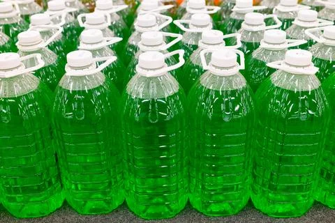 Green technical fluid in plastic bottles at the supermarket. Stock Photos