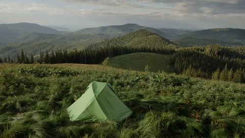 Green tent is in the mountains at sunset 스톡 동영상 77565943