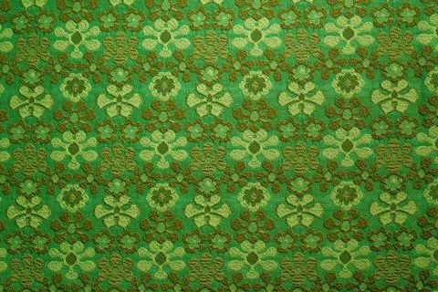Green textile fabric background featuring repeating decorative pattern with d Stock Photos