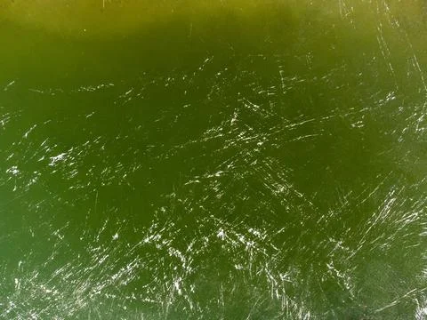 Green texture with white stripes. The texture of the ice lake. Stock Photos