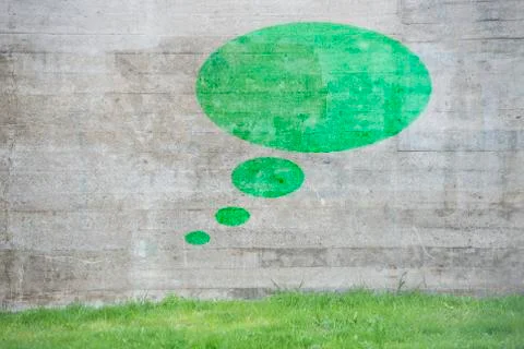Green thought bubble on concrete wall Stock Photos