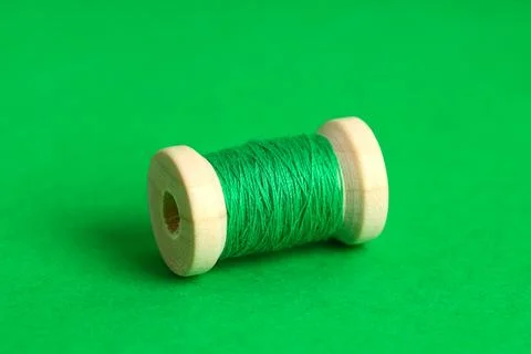 Green thread spool on color background, closeup Stock Photos