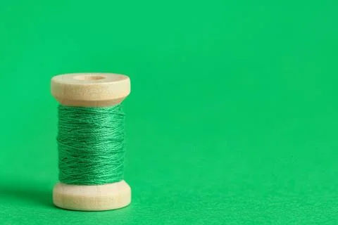 Green thread spool on color background, closeup Stock Photos