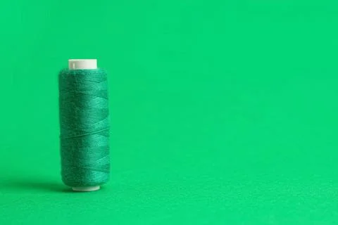 Green thread spool on color background, closeup Stock Photos