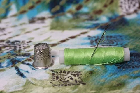 Green Thread With Thimble and Scissors on Vintage Fabric Stock Photos