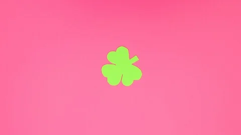 Green three leaf clover spin in circle on pink background - Stop motion Stock Footage 124302954