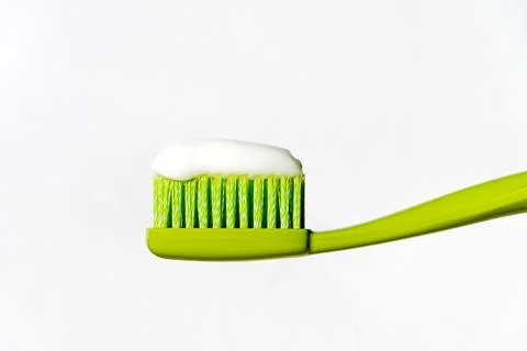 Green toothbrush with toothpaste on a white background. Isolated. Stock Photos