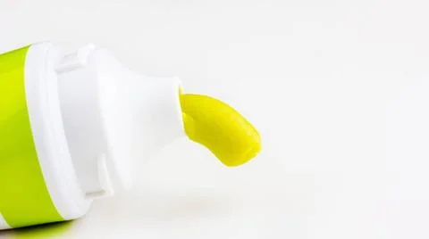 Green toothpaste is squeezed out of a tube of toothpaste close-up on a whi... Stock Photos