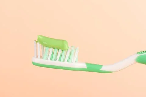 Green toothpaste on a toothbrush with space for text. Stock Photos