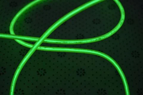 Green, toxically bright wire twisted into circle on fabric. Stockfoto's