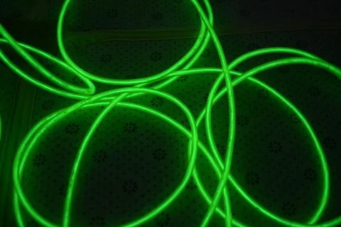 Green, toxically bright wire twisted into circle on fabric. Stockfoto's