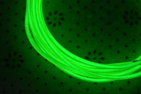 Green, toxically bright wire twisted into circle on fabric. Stockfoto's