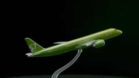 Green toy airplane model rotating on black background Stock Footage 153233433
