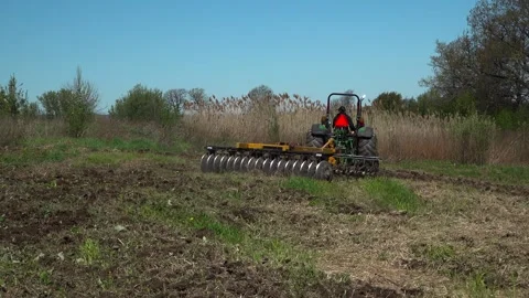 Green Tractor Executing a Turn with Disc Harrow on a Food Plot Field Stock Footage 346964903