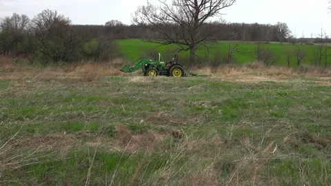 Green Tractor with Loader Operating in a Wide Open Field on an Ontario Farm Stock Footage 346962292