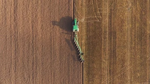 Green tractor plowing field preparing soil for sowing aerial view Video stock 312041506