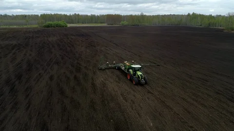 Green Tractor Plows, Tillages the Soil in Modern Crop Field Farming Agriculture. Stock Footage 127983802