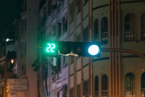 Green traffic light light up in city while night allows car to turn right Stock Photos