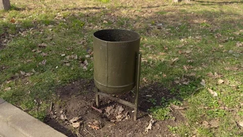 The Green Trash Bin located in the Park serves a vital purpose for Litter Stock Footage 305267346